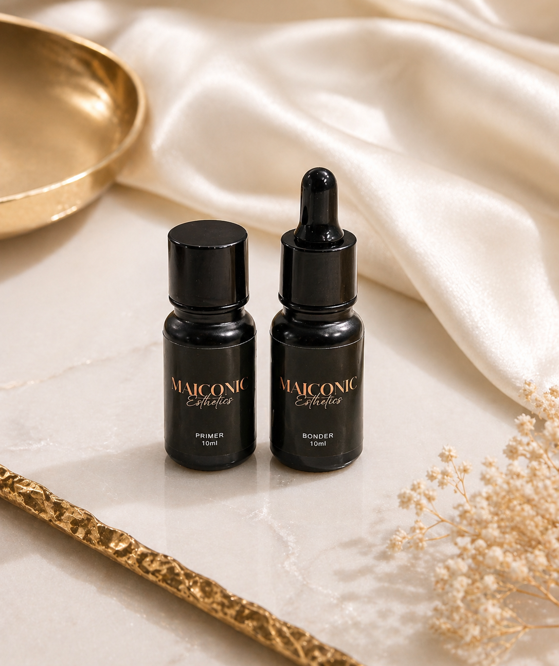 Lash bond and primer set in black bottles with gold accents that say Maiconic Esthetics