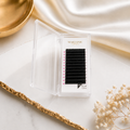 Eyelash extension tray with 'MAICONIC' branding on a marble surface.