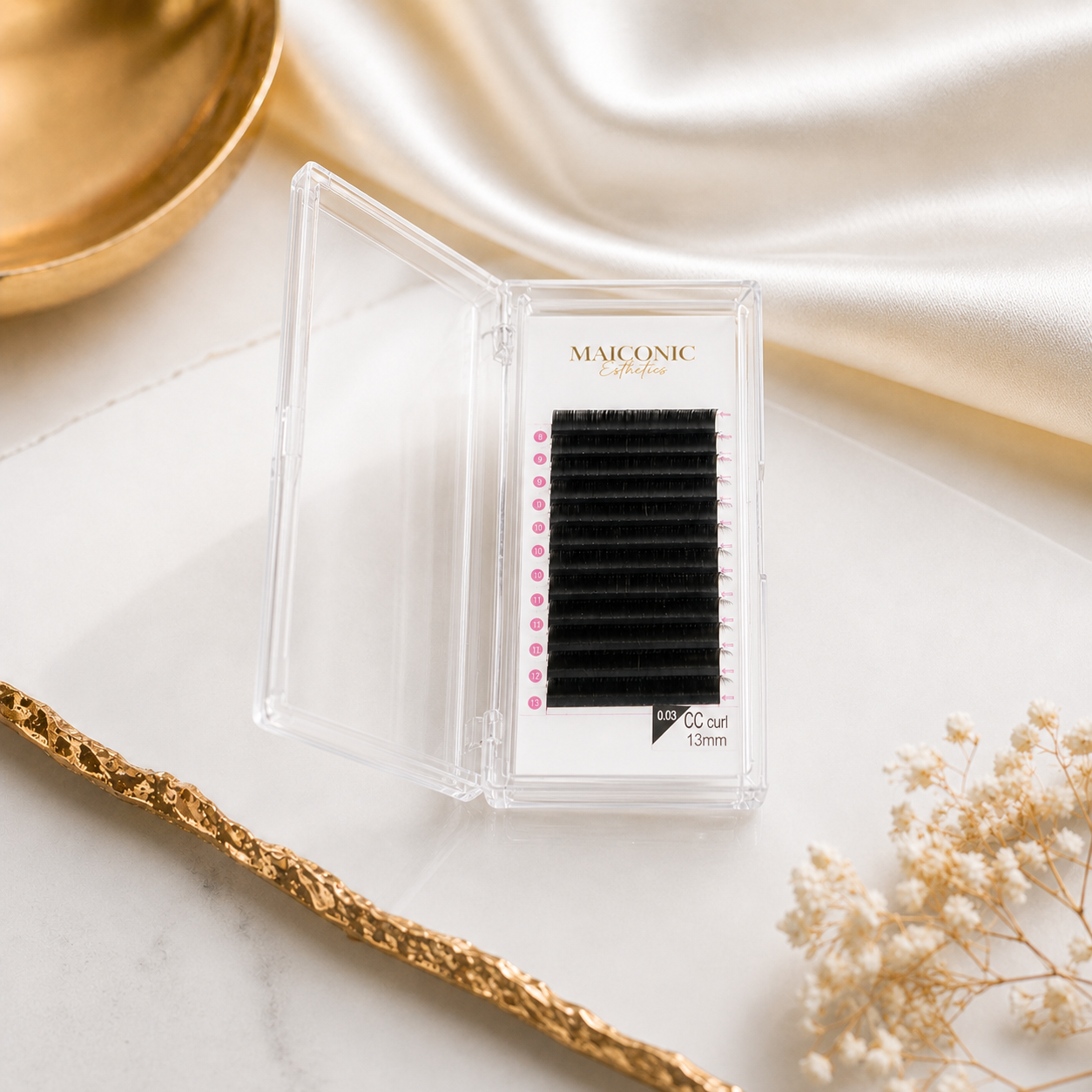 Eyelash extension tray with 'MAICONIC' branding on a marble surface.